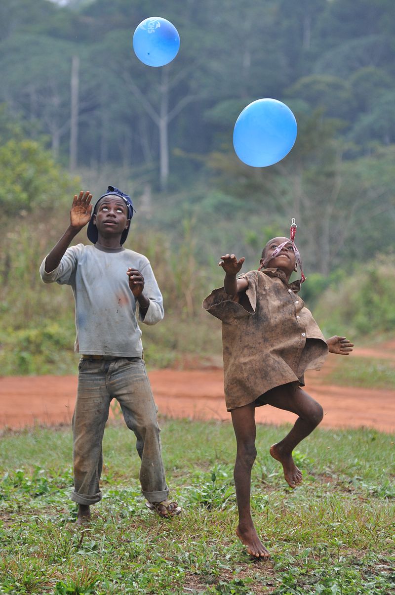 Deux enfants africains jouant avec des balons bleus